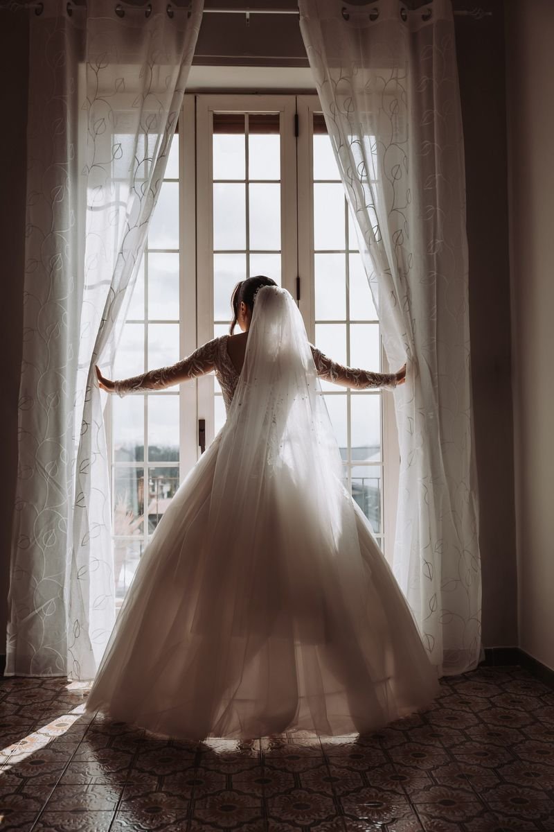 Bride in veil backlit by a window